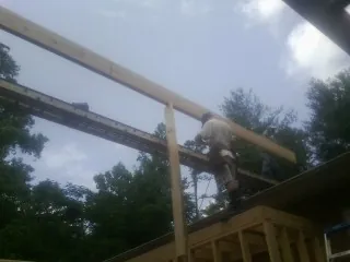 Carpenter setting a ridge beam over a new addition frame — Ice Dam Removal by Roofing Brothers in Petaluma